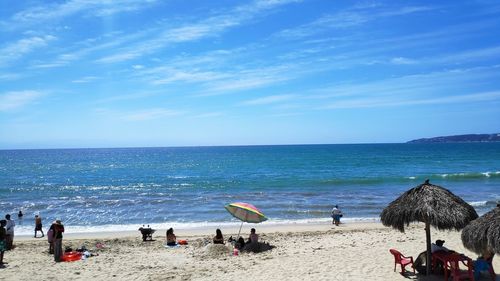 People on beach against blue sky