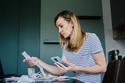 Woman calculating payment bill at home