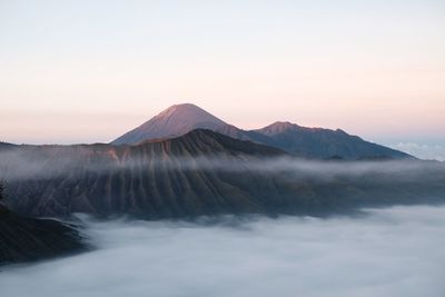 Scenic view of volcanic mountain against sky during sunset