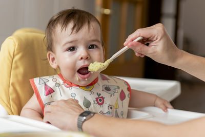 Girl child eating some baby food for lunch.