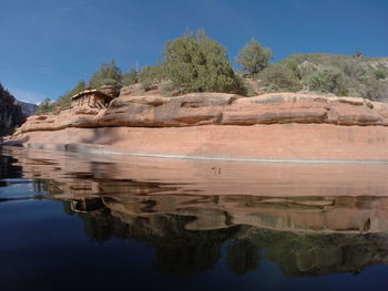 Reflection of rocks in lake against sky