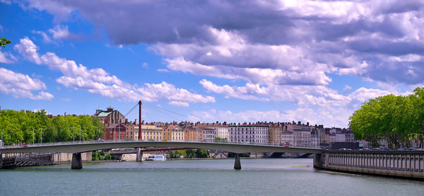 Bridge over river against cloudy sky