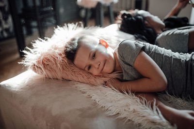 Portrait of woman lying on sofa at home