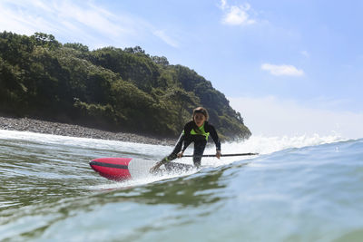 Female sup surfer on a wave