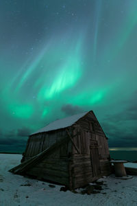 Abandoned building against sky at night during winter