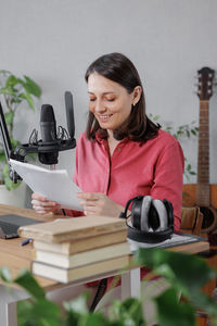 Young woman using digital tablet while sitting on table