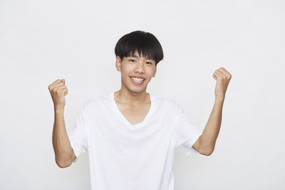 Portrait of smiling man standing against white background