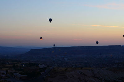 Hot air balloons in city at sunset