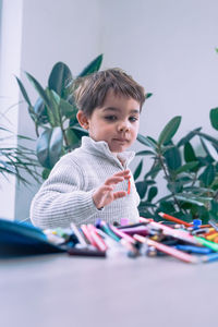 Portrait of cute boy sitting on table