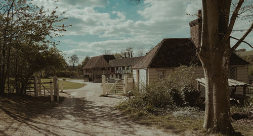 Houses by trees and buildings against sky