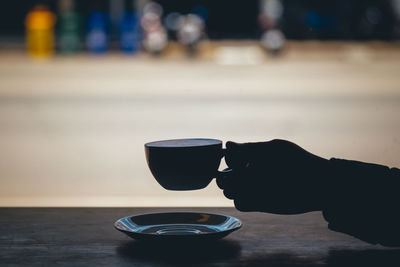 Person holding coffee cup on table