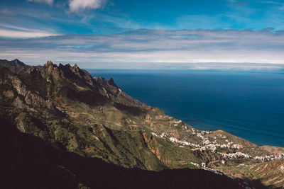 Scenic view of sea and mountains against sky