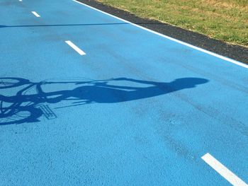 Shadow of person riding bicycle on street