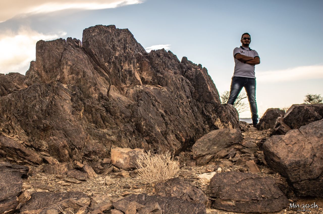 FULL LENGTH OF MAN STANDING ON ROCK