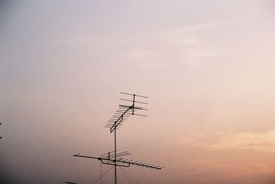 Low angle view of telephone pole against sky during sunset