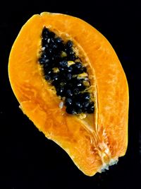 Close-up of orange slice against black background