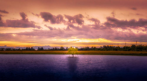 Scenic view of lake against romantic sky at sunset