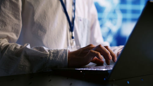 Midsection of businessman using laptop at office