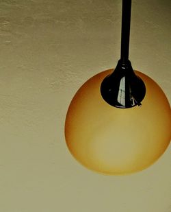 Close-up of electric lamp hanging on wall