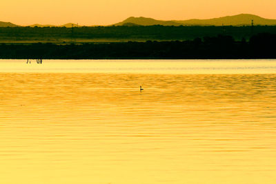 Scenic view of lake against sky at sunset