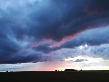 Scenic view of dramatic sky over silhouette landscape