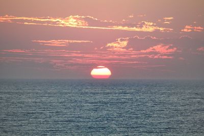 Scenic view of sea against romantic sky at sunset
