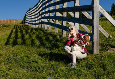 Woman is resting and holding her pet - cavalier king charles spaniel