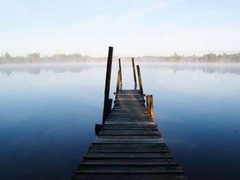 Pier over lake against clear sky