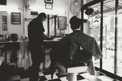 Rear view of man and woman standing on table