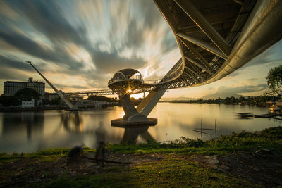 View of bridge over river against cloudy sky