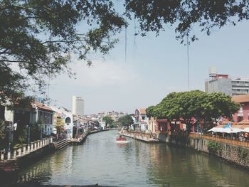 Canal amidst buildings in city against sky