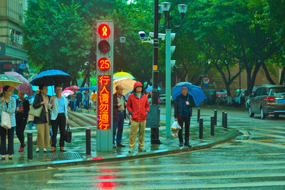 People walking on wet road in rainy season