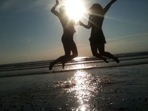 water, sun, sea, silhouette, sunlight, sunbeam, lifestyles, leisure activity, reflection, sunset, lens flare, beach, men, sky, full length, horizon over water, waterfront, mid-air