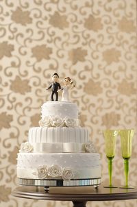 Close-up of wedding cake on table against wall