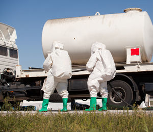 Rear view of workers walking towards vehicle