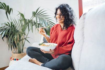 Brunette woman eating a healthy green salad.
