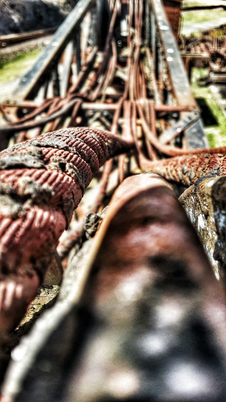 metal, close-up, selective focus, metallic, focus on foreground, day, abundance, no people, outdoors, stack, rusty, large group of objects, railroad track, in a row, sunlight, high angle view, connection, rope, heap, field