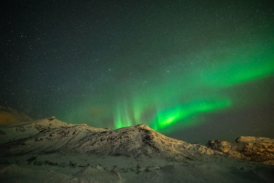 Scenic view of snowcapped mountains against sky at night