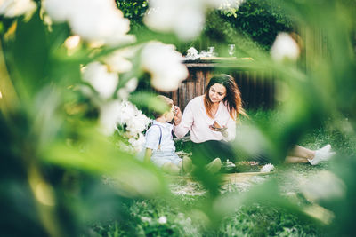 Portrait of young woman sitting on field