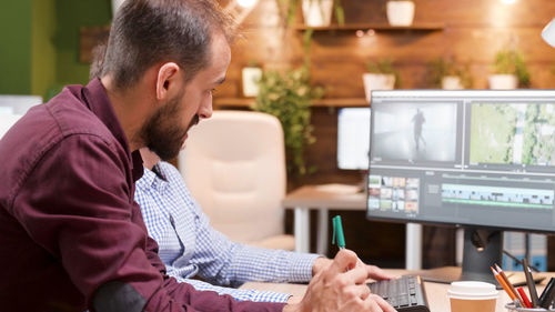 Side view of videographer working in office