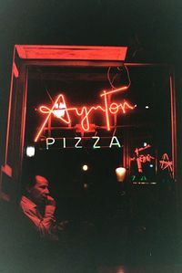 Illuminated text written on wall at night