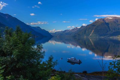 Scenic view of lake by mountains against sky