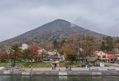 Tourists in town against cloudy sky