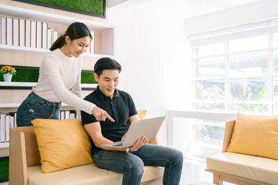 Young couple sitting on chair at home