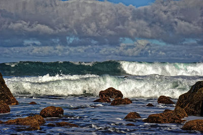 Rocks on beach against sky