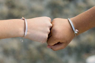 Cropped hands of friends fist bumping 