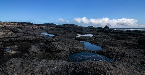 Rock formations by sea against sky