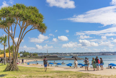 Beach umbrellas and palm trees on the sunset beach in the american village of okinawa.