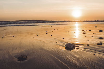 Scenic view of beach against sky during sunset