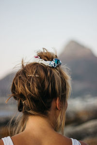 Rear view of woman with arms raised against sky